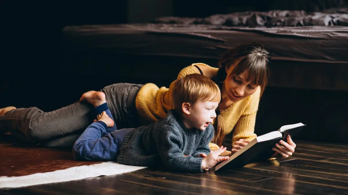 Une mère et son fils en train de lire sur le sol