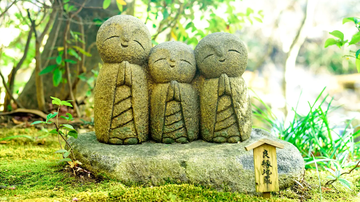 Trois statues Jizo alignées sur un rocher